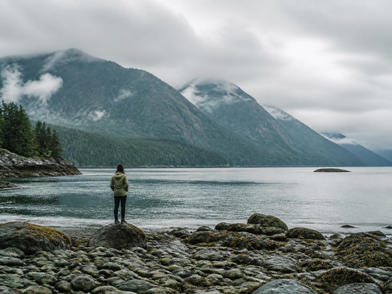 A person taking in the Pacific Northwest coastline and mountains